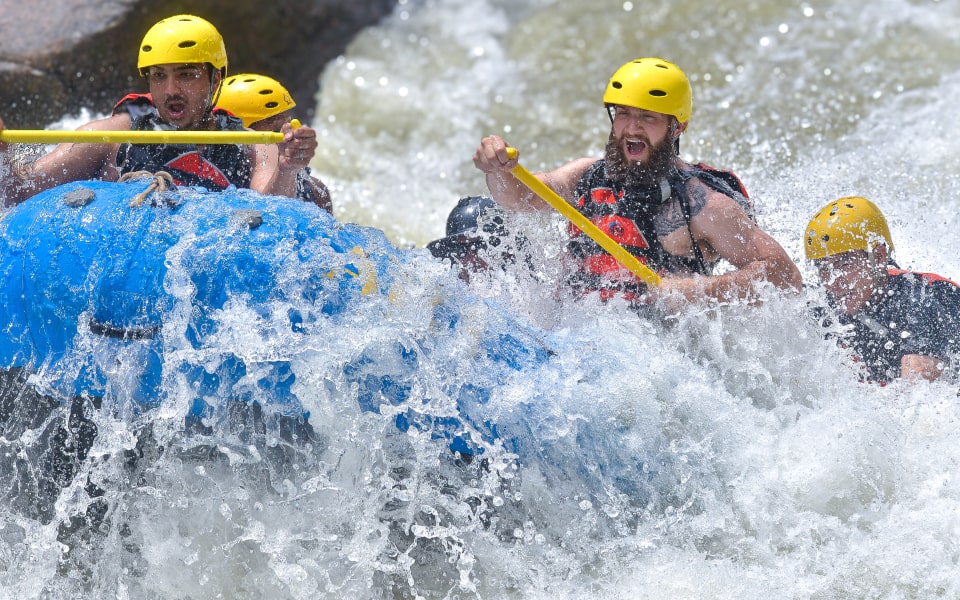 whitewater rafters getting splashed while rafting