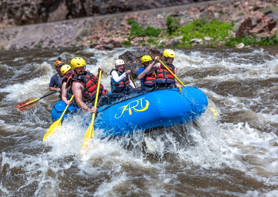whitewater rafters paddling through a rapid